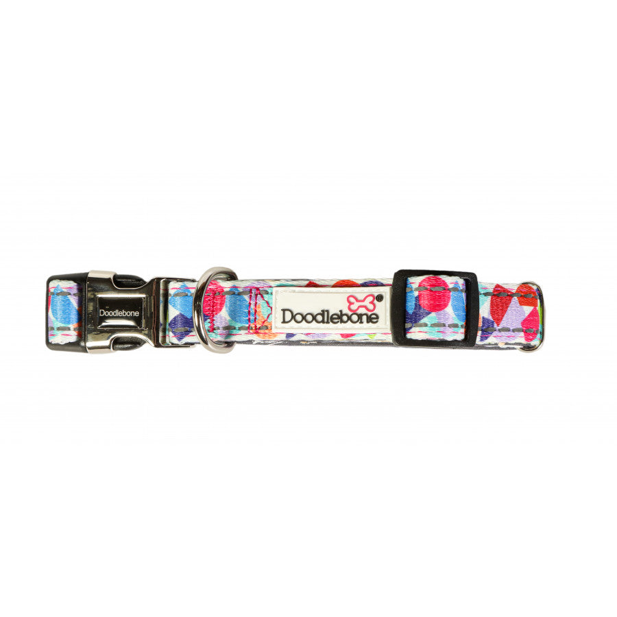 Image shows a bright abstract print dog collar with a mixture of reds, blues, orange and green finished off with a silver clip and the white doodlebone logo