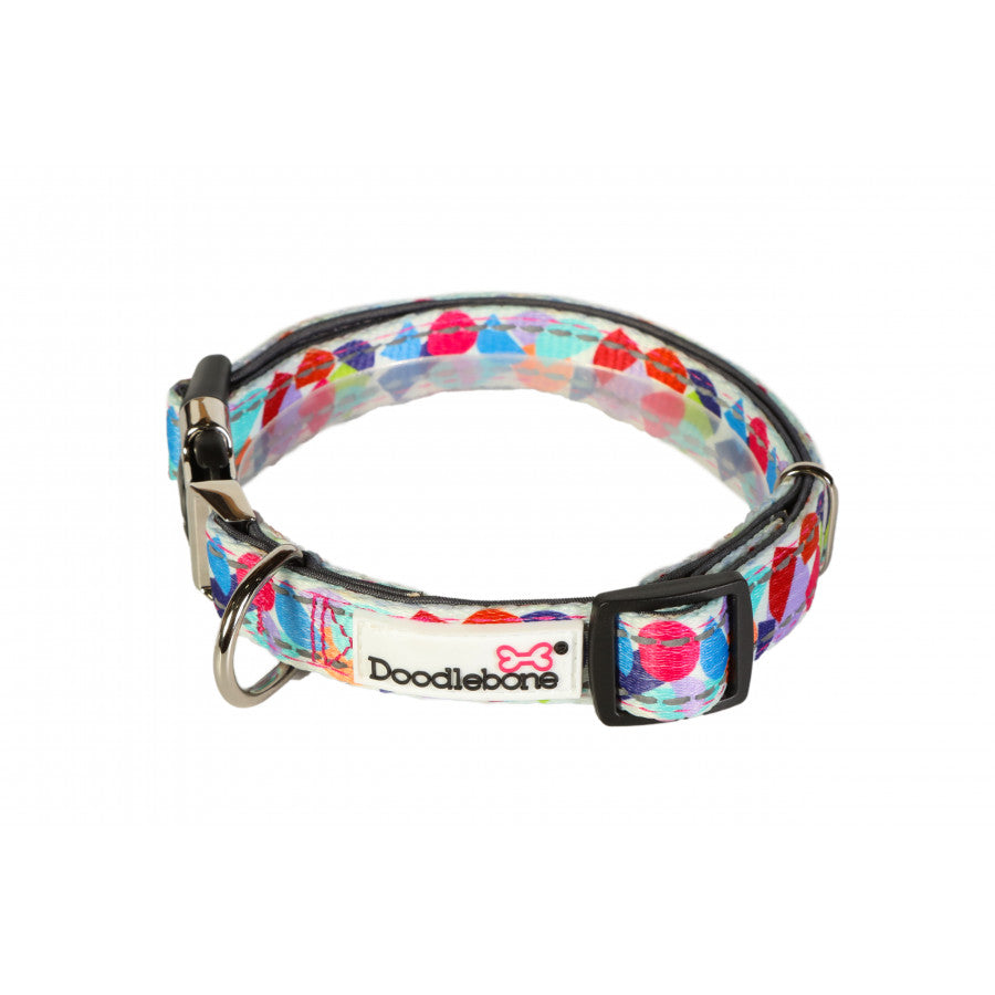 Image shows a bright abstract print dog collar with a mixture of reds, blues, orange and green finished off with a silver clip and the white doodlebone logo