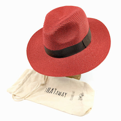 Image shows a red panama hat with a black ribbon around the centre