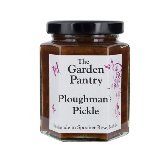 Image shows a glass jar with a black lid of Ploughmans Pickle. the pickle is a dark brown in colour