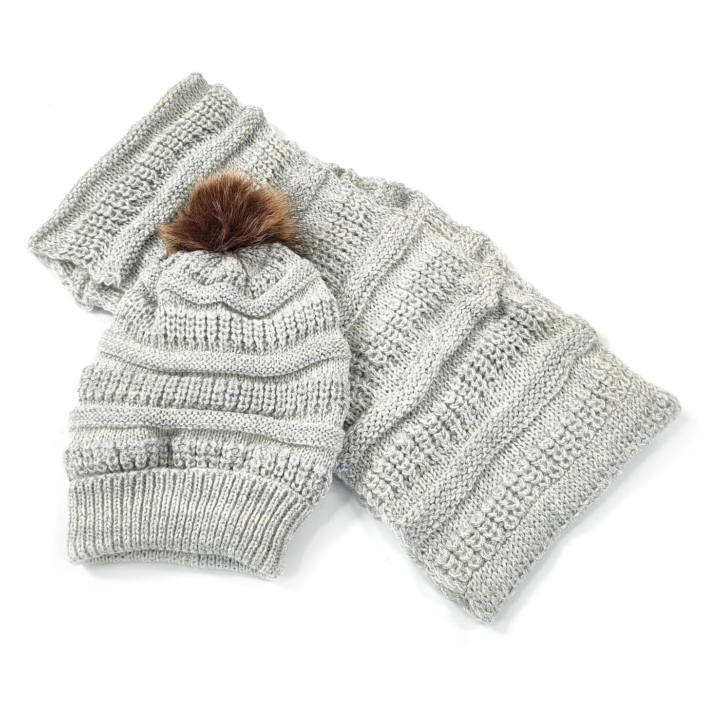 Image shows a matching cable knit bobble hat with brown fluffy pom pom on the top and  grey and silver cable knit snood